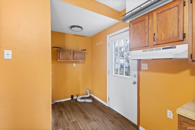 clothes washing area with wood-type flooring