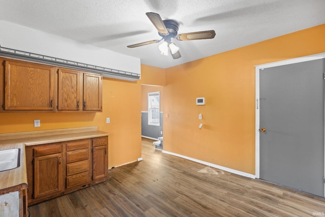 kitchen with hardwood / wood-style floors, a textured ceiling, and ceiling fan