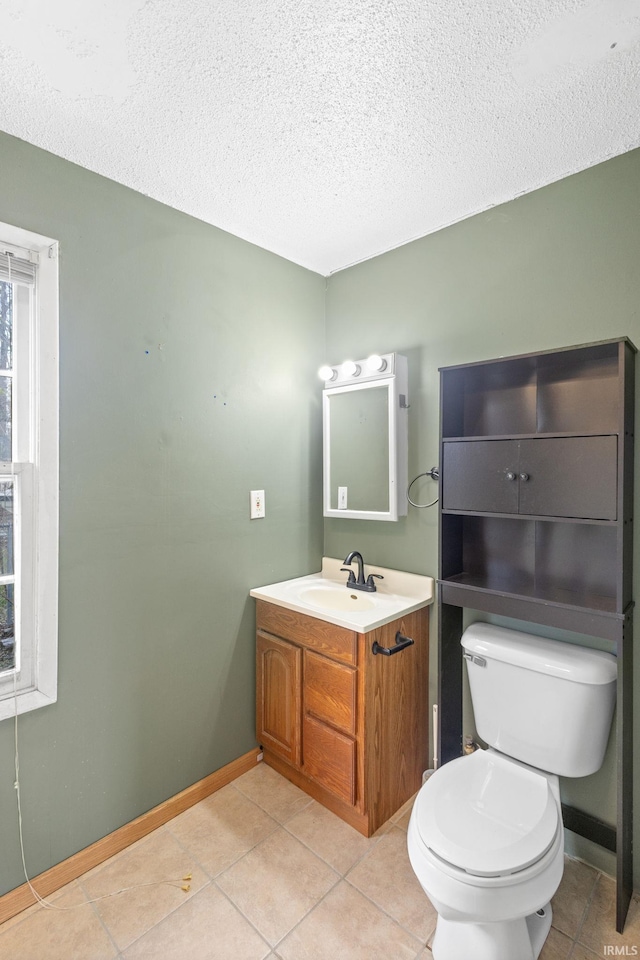 bathroom featuring tile patterned floors, vanity, a textured ceiling, and toilet