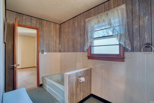 bathroom with wooden walls and a bath