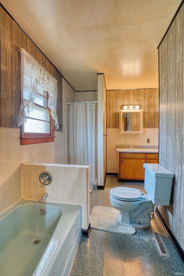 bathroom featuring wood walls, vanity, and toilet