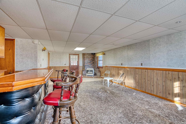 bar featuring a drop ceiling and wood walls