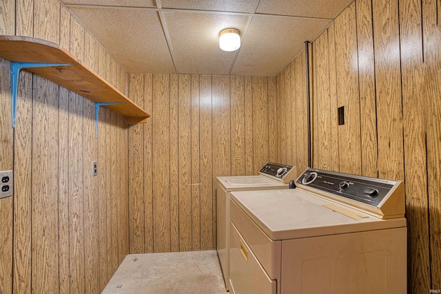 laundry area with separate washer and dryer, wooden walls, and carpet