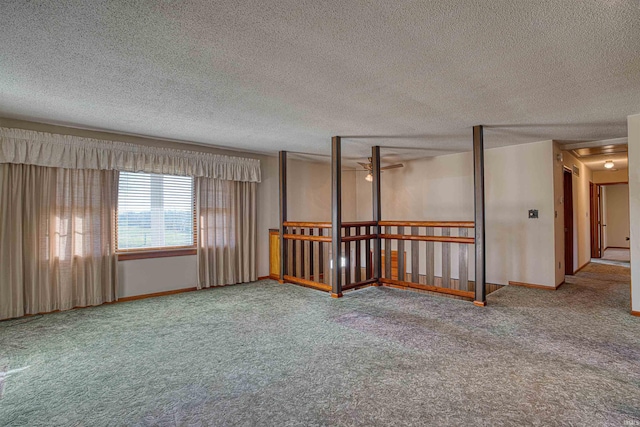 carpeted spare room featuring ceiling fan and a textured ceiling