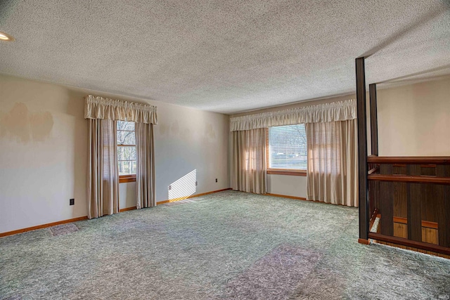 carpeted spare room featuring a healthy amount of sunlight and a textured ceiling