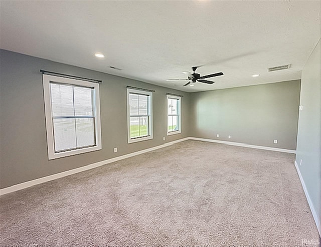 empty room featuring ceiling fan and carpet