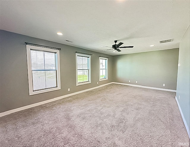 carpeted spare room with a textured ceiling and ceiling fan