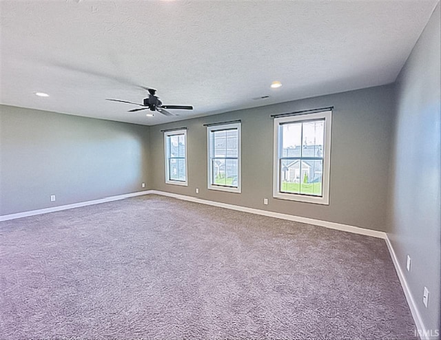 spare room featuring carpet, ceiling fan, and a textured ceiling