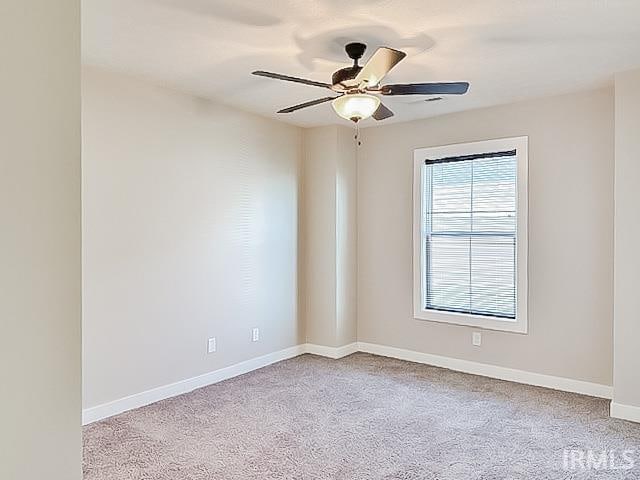 carpeted spare room featuring ceiling fan