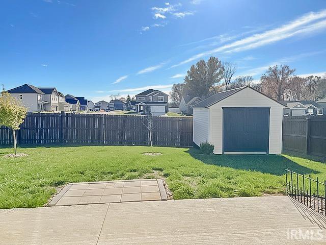 view of yard featuring a storage unit and a patio area