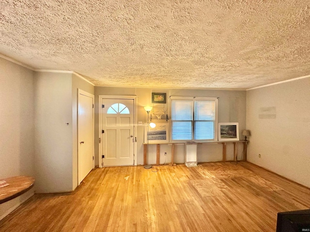 entrance foyer with light hardwood / wood-style flooring, a healthy amount of sunlight, and a textured ceiling