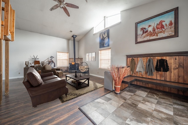 living room with a wood stove, ceiling fan, and high vaulted ceiling