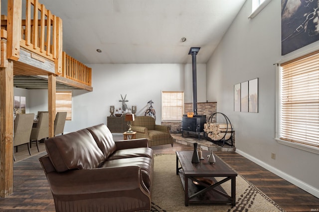 living room with a wood stove, dark wood-type flooring, and a high ceiling