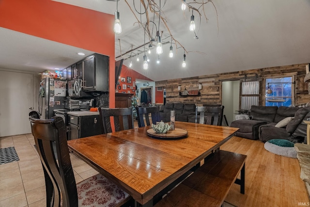 dining area featuring light tile patterned floors and vaulted ceiling