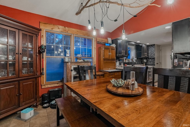 dining room with light tile patterned floors and vaulted ceiling