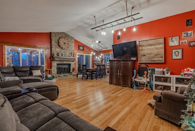 living room with a textured ceiling, a fireplace, hardwood / wood-style floors, and lofted ceiling