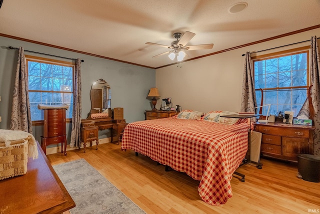 bedroom with a textured ceiling, ceiling fan, light hardwood / wood-style floors, and crown molding