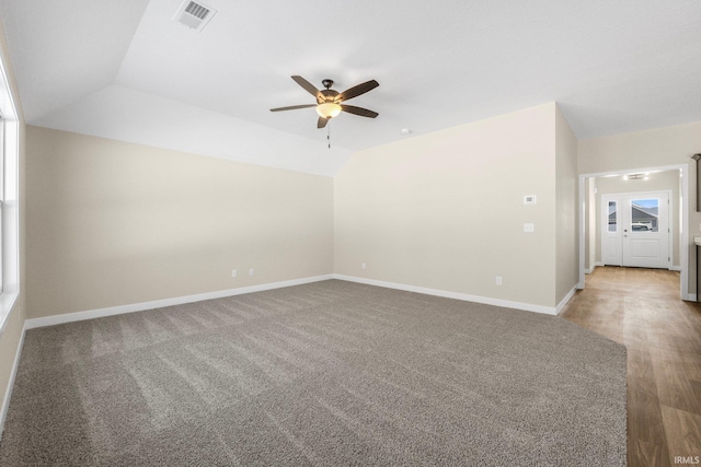 carpeted spare room with ceiling fan and lofted ceiling