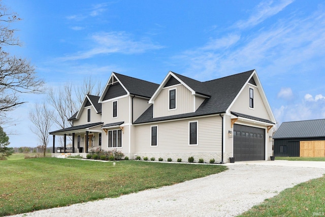 view of front of property with covered porch, a garage, and a front lawn