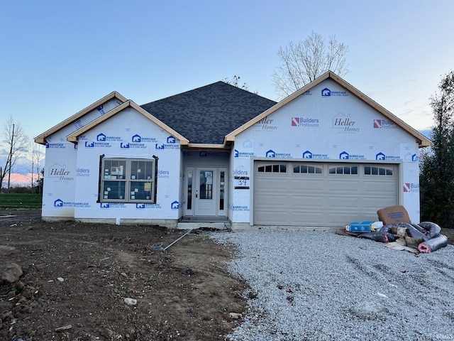 property in mid-construction with driveway, roof with shingles, and an attached garage