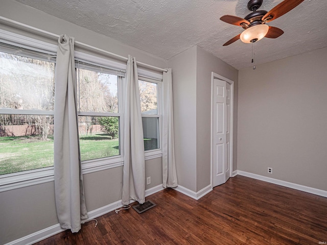 spare room featuring ceiling fan, dark hardwood / wood-style flooring, and a textured ceiling