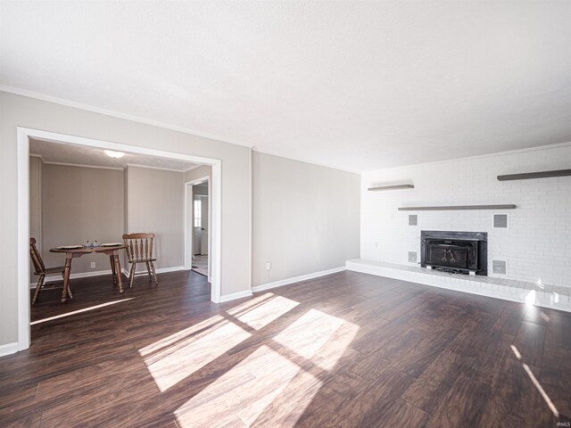 unfurnished living room with dark hardwood / wood-style flooring, ornamental molding, and a brick fireplace