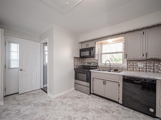 kitchen featuring tasteful backsplash, gray cabinetry, sink, black appliances, and plenty of natural light