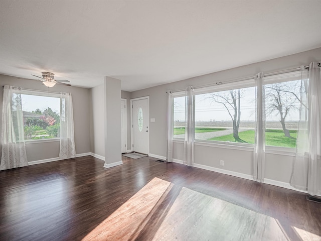 spare room with dark hardwood / wood-style flooring and ceiling fan