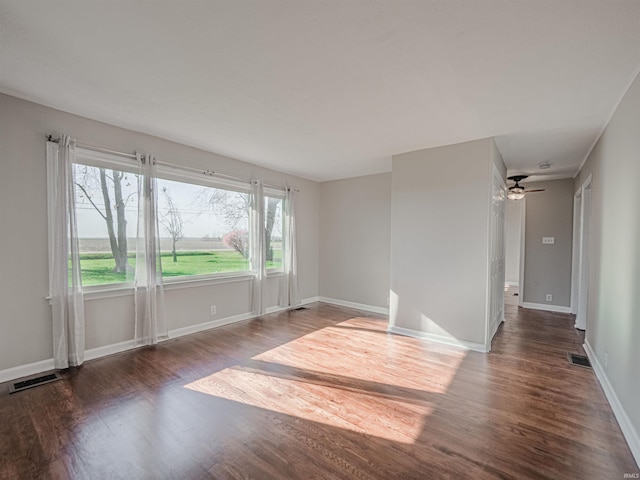 unfurnished room with dark hardwood / wood-style floors and ceiling fan