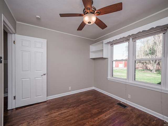 unfurnished room with ceiling fan, ornamental molding, and dark wood-type flooring