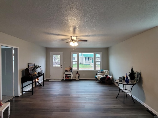 sitting room with dark hardwood / wood-style floors, ceiling fan, and a textured ceiling