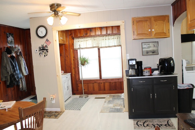 kitchen featuring ceiling fan and wooden walls