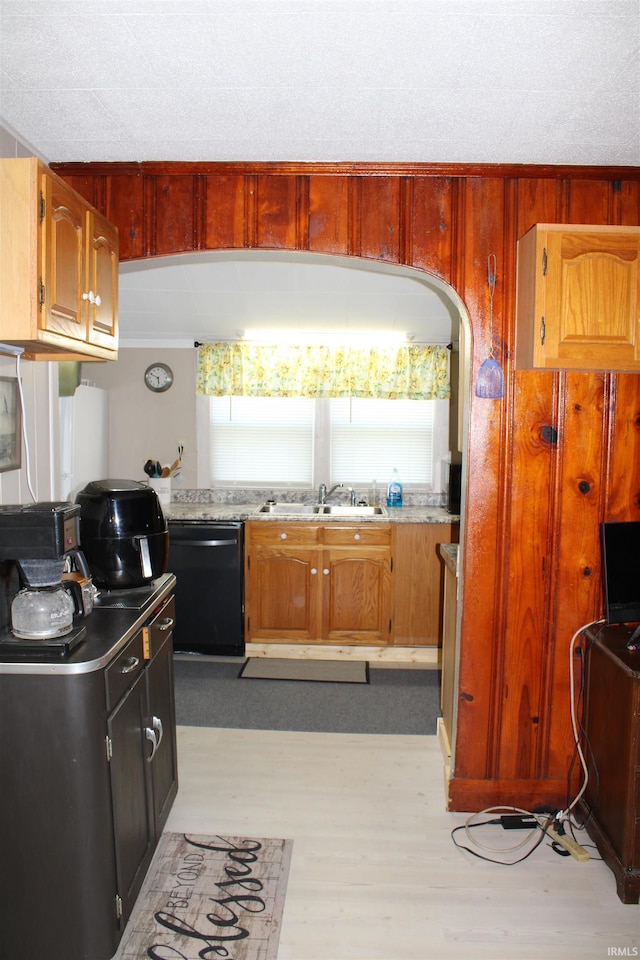 kitchen featuring sink, light hardwood / wood-style flooring, a textured ceiling, and black dishwasher