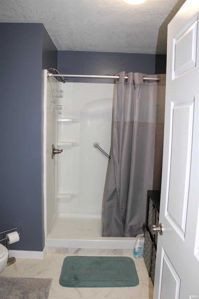 bathroom with a textured ceiling and curtained shower