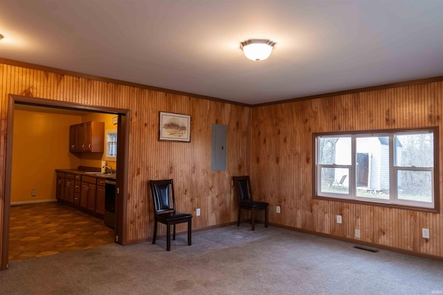 miscellaneous room featuring dark carpet, electric panel, crown molding, wooden walls, and sink