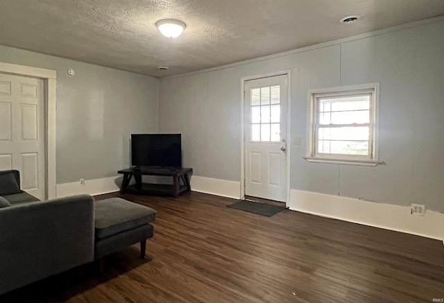 living room with a textured ceiling and dark wood-type flooring