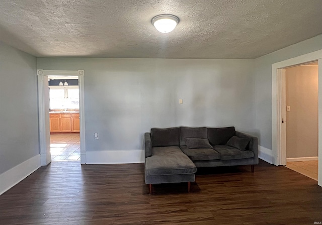 living room featuring dark hardwood / wood-style flooring and a textured ceiling