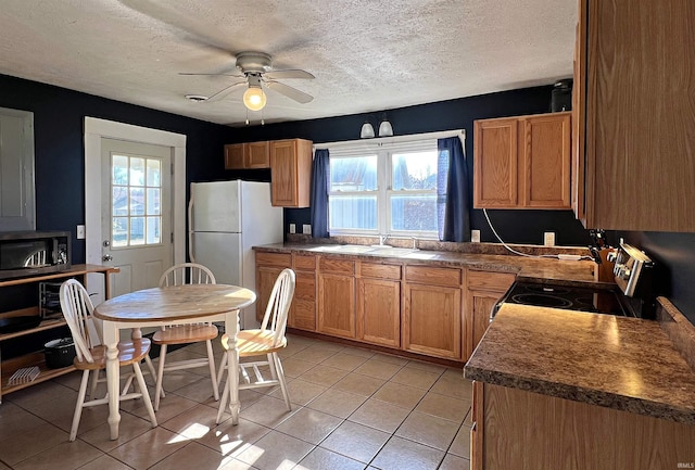 kitchen featuring light tile patterned flooring, stainless steel appliances, plenty of natural light, and ceiling fan