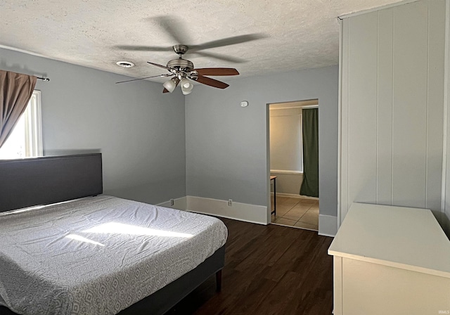 bedroom featuring ceiling fan, dark wood-type flooring, and a textured ceiling