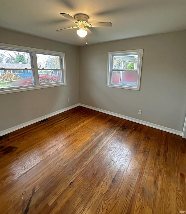 unfurnished room with ceiling fan, hardwood / wood-style floors, and a healthy amount of sunlight