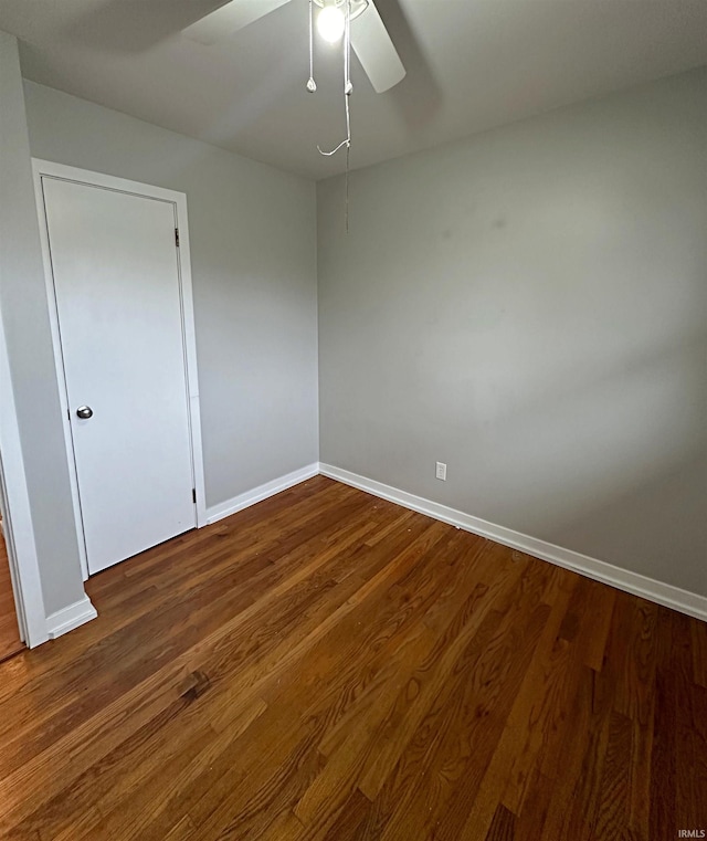 empty room with ceiling fan and dark wood-type flooring