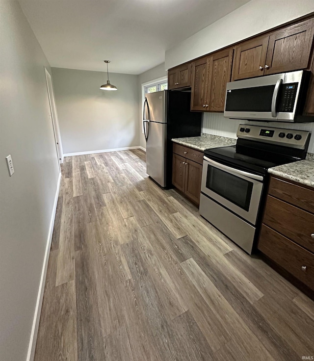 kitchen featuring dark brown cabinets, stainless steel appliances, and light wood-type flooring