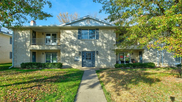 view of front of home with a balcony and a front yard