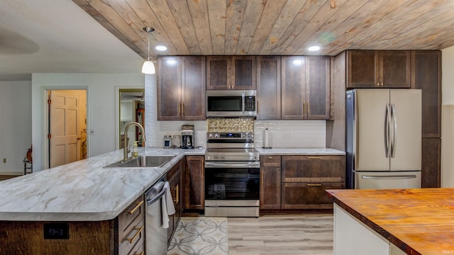 kitchen featuring sink, hanging light fixtures, light hardwood / wood-style floors, dark brown cabinets, and appliances with stainless steel finishes