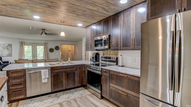 kitchen featuring kitchen peninsula, french doors, stainless steel appliances, sink, and light hardwood / wood-style floors