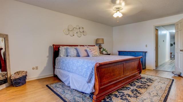 bedroom with ceiling fan and light hardwood / wood-style floors