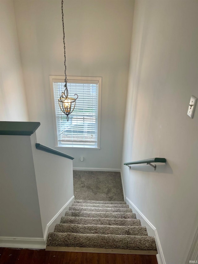 staircase featuring a chandelier