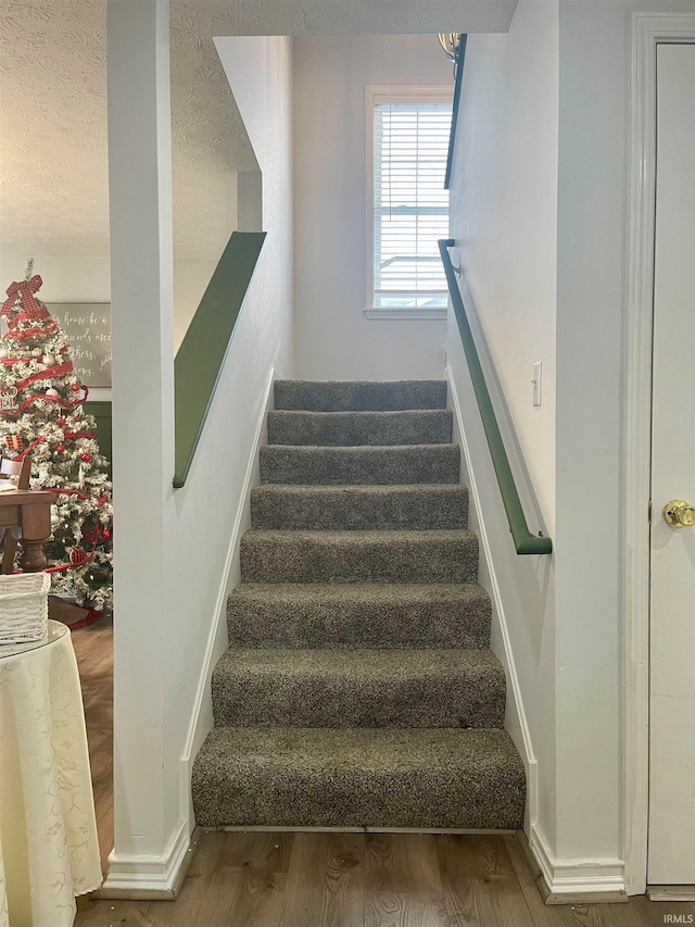 stairway featuring hardwood / wood-style floors and a textured ceiling