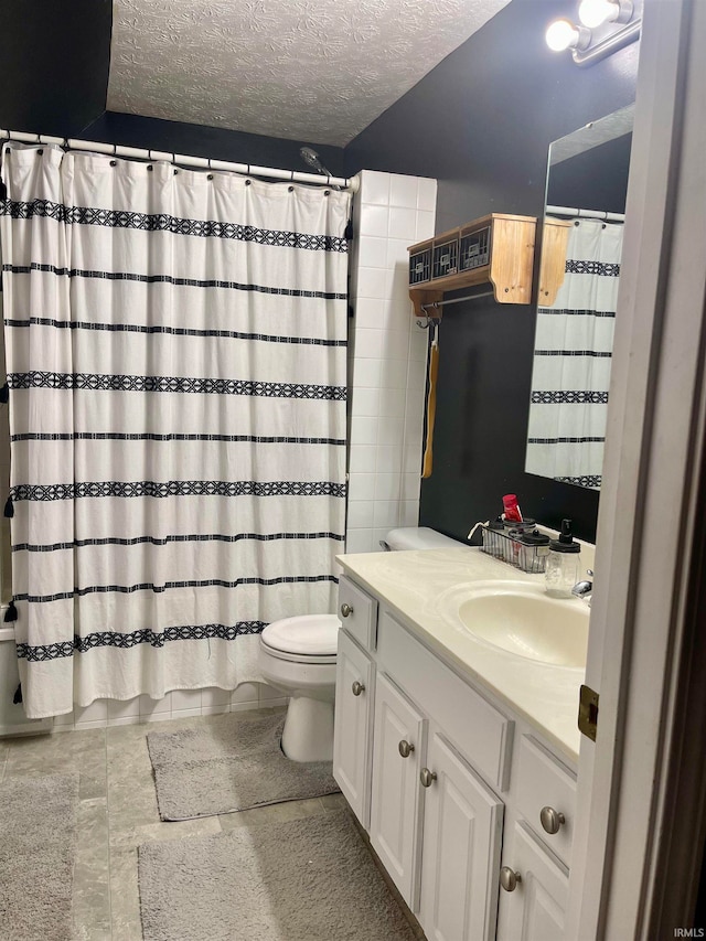 bathroom featuring vanity, tile patterned flooring, toilet, a textured ceiling, and curtained shower