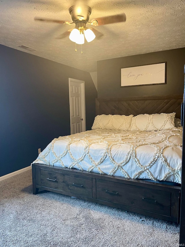 bedroom with carpet, a textured ceiling, and ceiling fan